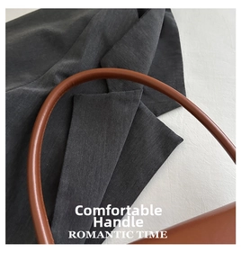 Macro shot of a dark brown leather handbag handle with a matte finish and curved design