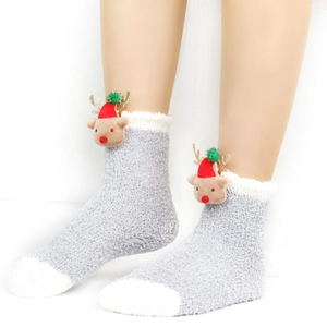 Detail eines flauschigen grauen Korallenfleece-Weihnachtssockens mit Rentierpuppe und Pompons