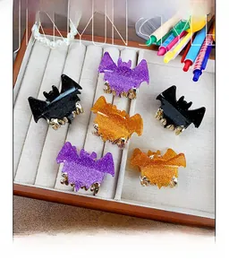 Macro shot of glittery acrylic bat hair claws in purple, black and orange colors