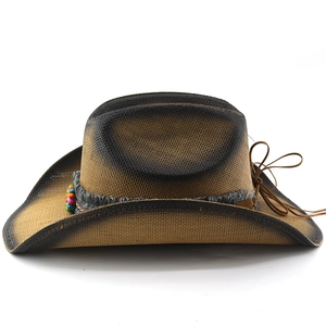 Détail du chapeau de cowboy en paille avec perles ethniques et texture tissée dégradée