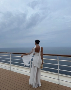 Elegant white backless halter maxi dress in flowing chiffon fabric for resort vacation