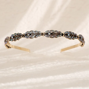 Detail of antique gold bridal headband with sparkling leaf-shaped colorful rhinestones