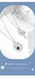 Detail of 925 sterling silver necklaces with moon pendant and blue gemstone on white stone
