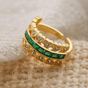 Gold plated open ring featuring square green emeralds and heart shaped zircon accents