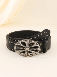 Detail of a black leather punk belt featuring vintage silver cross floral buckle and studs