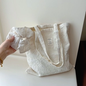 Detail of white French lace embroidery tote bag and matching floral hair scrunchie set