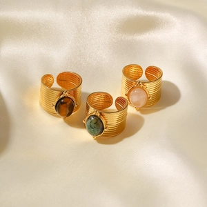 18K gold plated wide band rings with oval colored stones on beige silk background