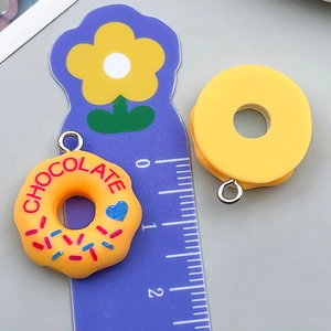Detail showing 2cm resin donut pendants with a ruler to demonstrate actual size
