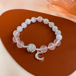 Detail of beaded bracelet with pink crystal, cat eye stones and zircon moon pendant
