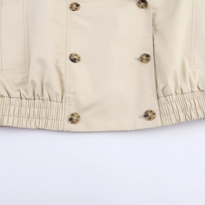 Women's beige waterproof cropped trench coat with double-breasted buttons and elastic hem