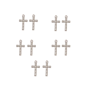Detailed view of ten silver cross pendants with shimmering cubic zirconia stones on white