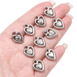 Macro shot of silver plated heart charms for DIY jewelry making held in a hand