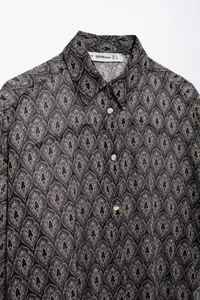 Nahaufnahme von Reverskragen und goldenen Knöpfen am Chiffonhemd mit Paisley-Muster