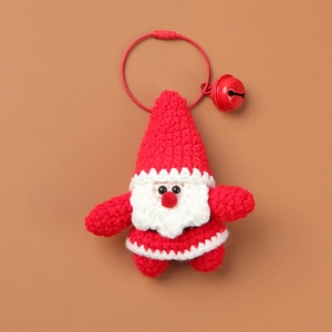 Macro view of handmade crochet Santa keychain with red metal wire loop and small bell