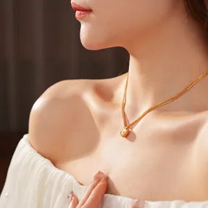 Elegant gold double layered heart pendant necklace for women worn with white lace top