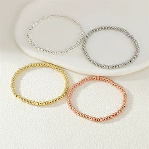 Close-up of elastic bead bracelets in gold, silver, rose gold, and gunmetal finishes