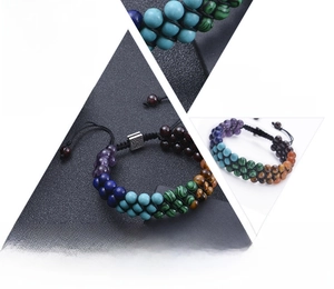 Details von sieben Chakra-Natursteinen und Lebensbaum-Anhänger am geflochtenen Armband