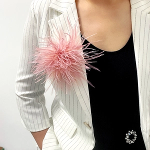 Elegant pink ostrich feather brooch pinned on a white pinstripe suit jacket lapel