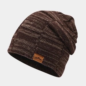 Detail of mixed-color knitted beanie with leather logo patch and warm fleece lining