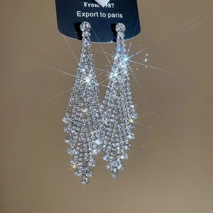 Nahaufnahme eleganter langer Silberquasten-Ohrringe mit glitzernden Strasssteinen