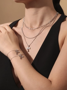 Detail van een gelaagde zilveren halsketting en armband set met 5A zirkoon hangers