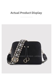 Detail of black lychee grain PU bag with geometric patterned woven strap and gold hardware