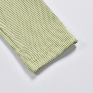 Macro detail of light green ribbed knit sleeve with professional double-needle stitching
