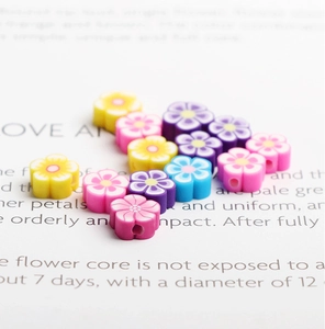 Macro shot of 12mm colorful polymer clay flower beads with central hole for DIY crafts