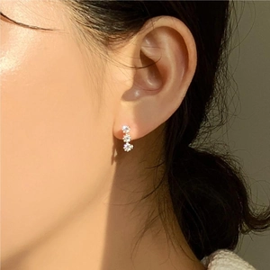 Elegant 925 sterling silver stud earrings with three vertical zircon flowers on model