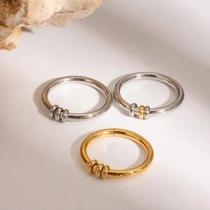 Macro detail of gold and silver stainless steel spinner rings with sliding relief beads