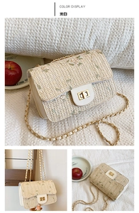 Detail of off-white straw bag with floral embroidery, gold twist lock and chain strap