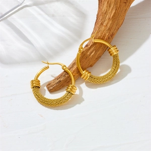 Boucles d'oreilles créoles dorées texture tressée en acier inoxydable sur bois