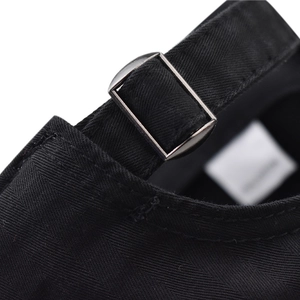 Detail of adjustable metal buckle and black cotton strap on the distressed baseball cap