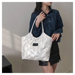 Detail der weißen gesteppten Puffer-Tasche mit schwarzem Fashion Bags Label vorne