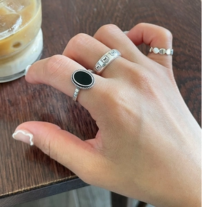 Close-up of minimalist 925 silver rings set featuring bear patterns on model's hand