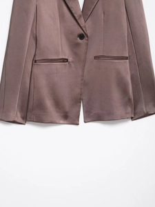 Detail of satin blazer showing smooth fabric texture and flap pocket in mauve
