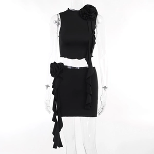 Detailed view of 3D fabric flower and ruffle fringe on black two-piece mini skirt set