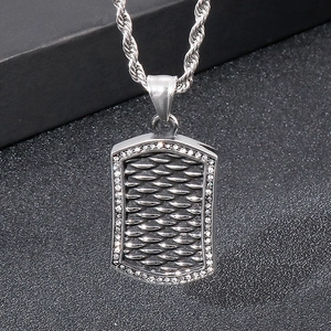 Close-up of silver punk dog tag pendant with fish scale texture and cubic zirconia crystals