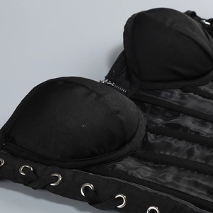 Detail of black corset top featuring metal eyelets, lace-up side ties and zipper closure
