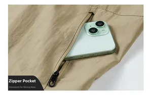 Detail van ritszak op de kaki outdoor jas met veel ruimte voor een mobiele telefoon