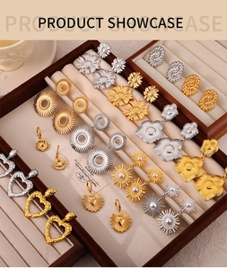 Detailed showcase of gold and silver sunburst flower and heart dangle earrings on velvet