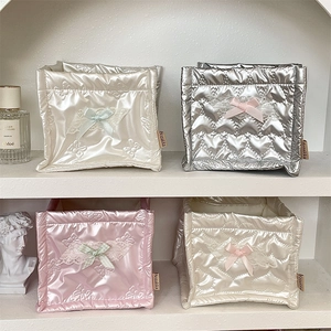 Detailed view of quilted PU storage baskets with lace bows and satin texture on a shelf
