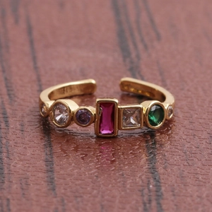 Vue macro d'une bague ajustable dorée ornée de pierres de zircone multicolores éclatantes