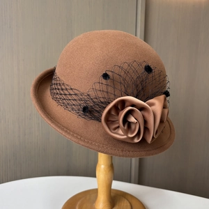 Detail of vintage brown wool felt hat featuring elegant black polka dot mesh and satin flowers