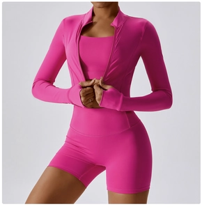 Three-piece pink yoga set detail: zip-up jacket with thumbholes and high-waist shorts