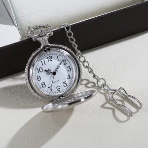 Vintage silver quartz pocket watch with flip cover and chain on a textured surface