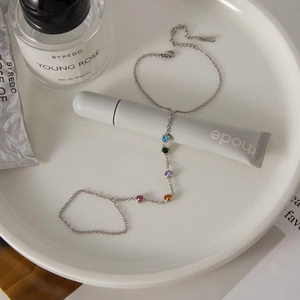 Detailed view of stainless steel bracelet featuring five colorful zircon stones in a tray