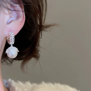 Detailed view of French vintage pearl earrings with lace texture and micro-inlaid diamonds