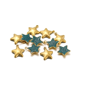 Macro shot of gold star pendants with turquoise rhinestones for DIY jewelry making