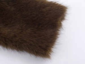 Détail de la veste en fausse fourrure marron foncé montrant la texture des fibres